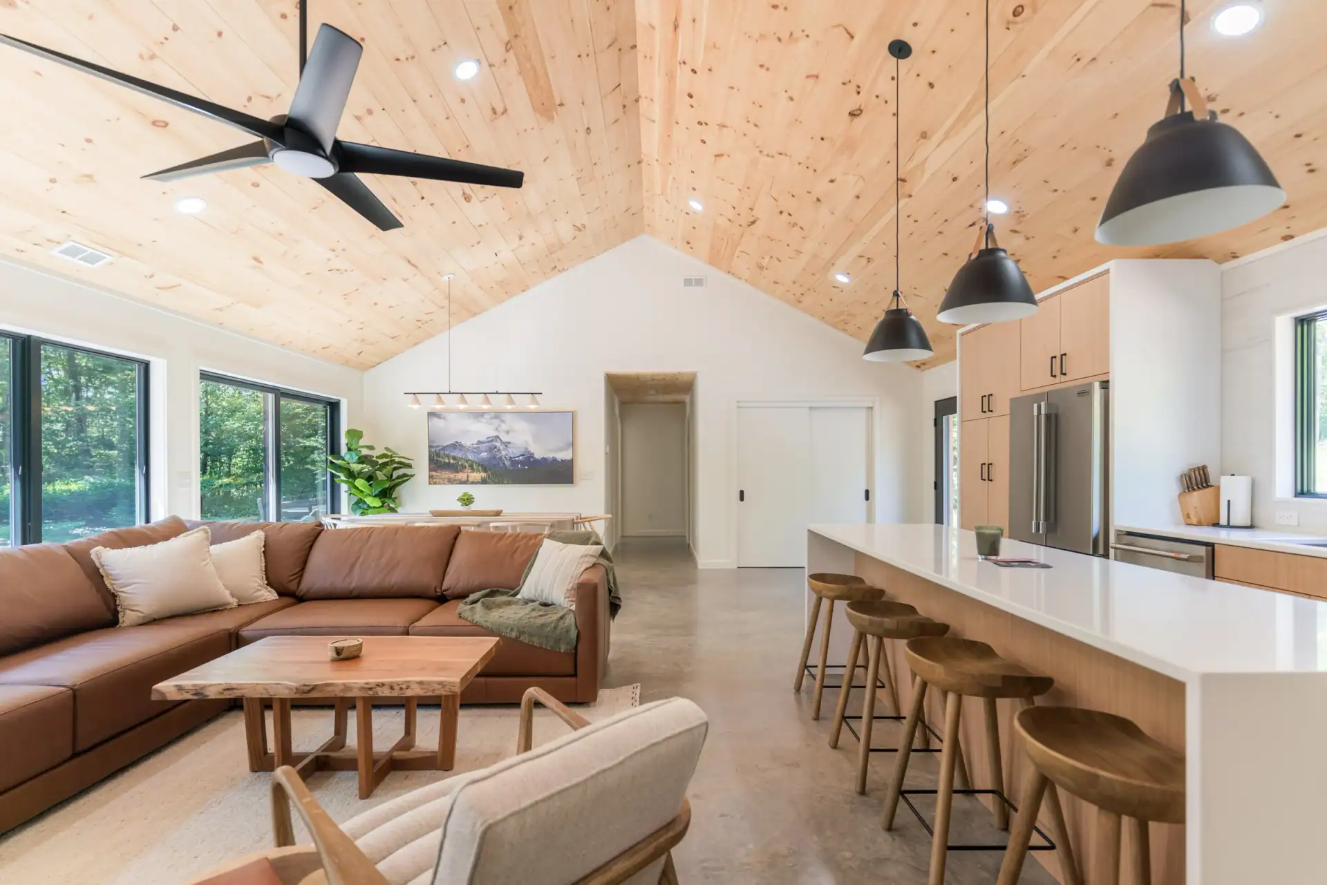 Casa Vetta’s open living room, dining area, and kitchen beneath vaulted pine ceilings